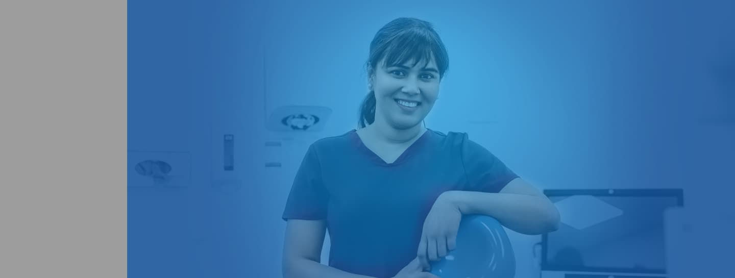 Employers ADVICE Standard Header 1440X545px A female dentist wearing scrubs smiling into the camera