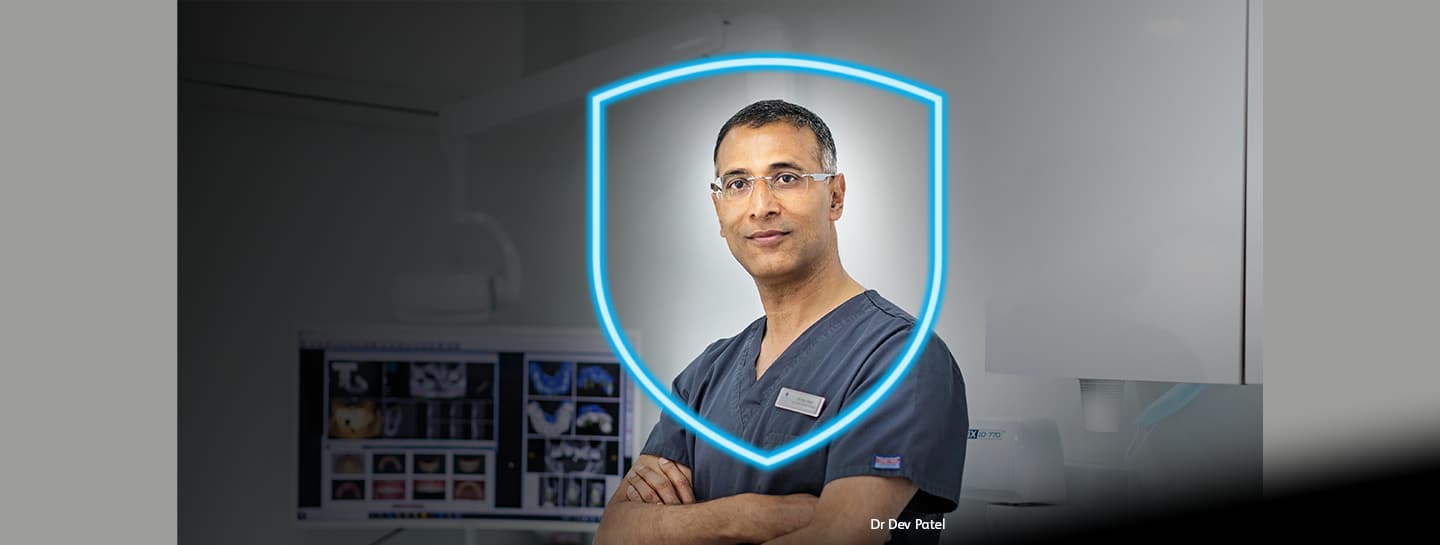 Indemnity hero launch Dr Dev Patel looks at the camera through a light blue shield signifying protection